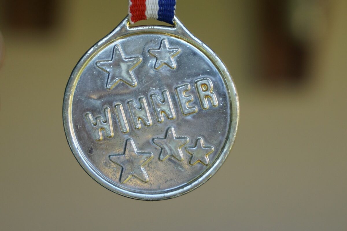 gold medal on red white and blue ribbon with the word winner engraved