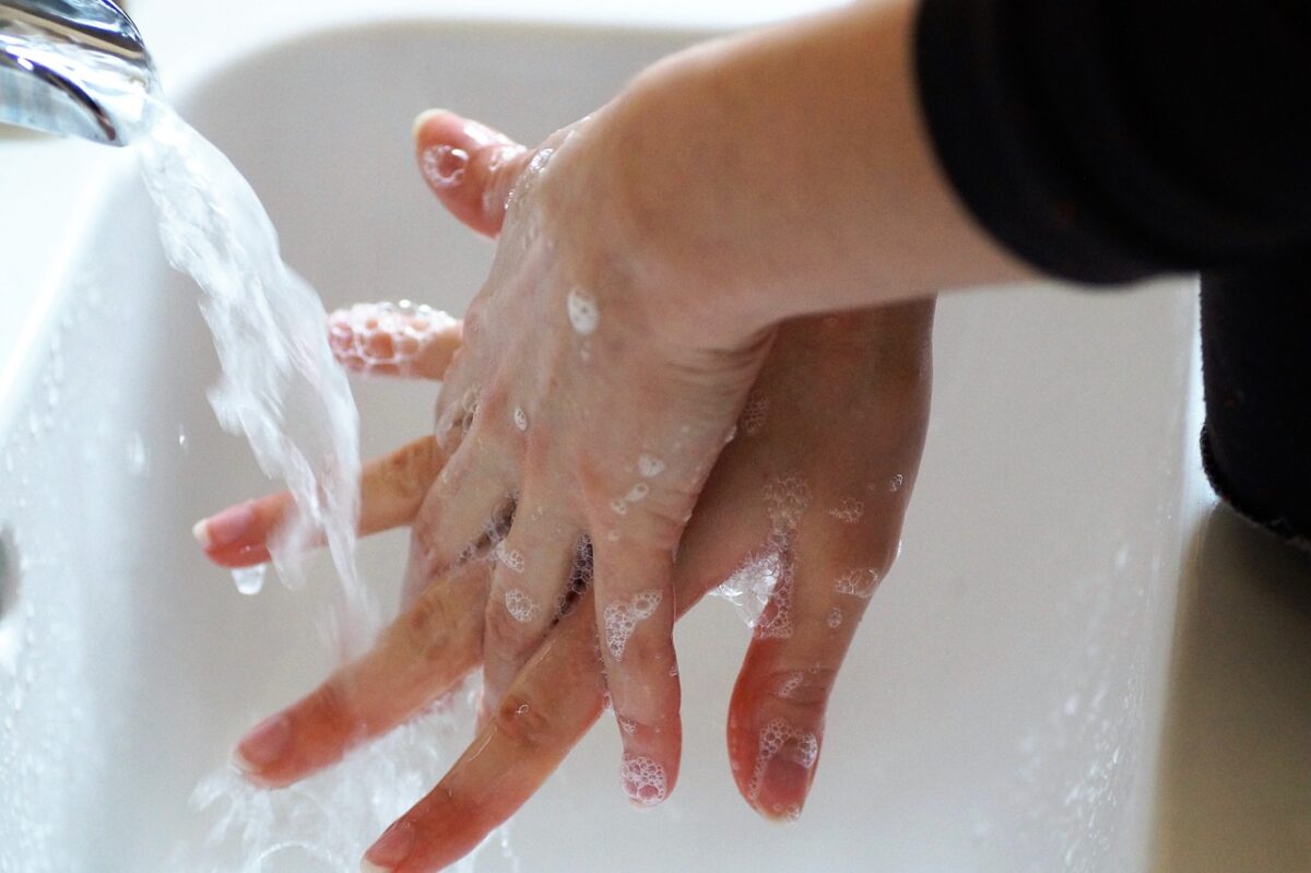 person washing hands under tap
