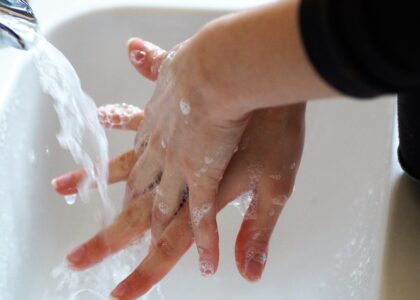person washing hands under tap