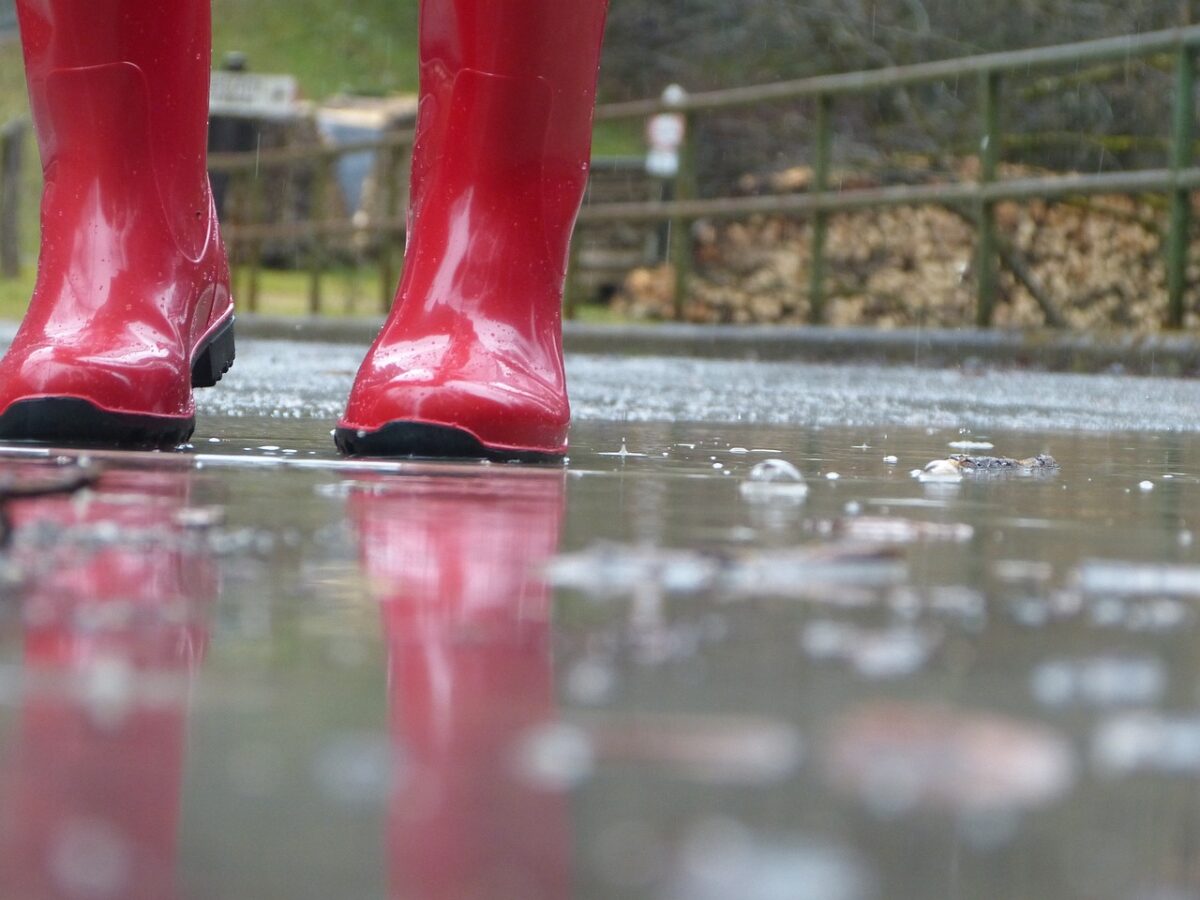red wellington boots on a rainy pavement