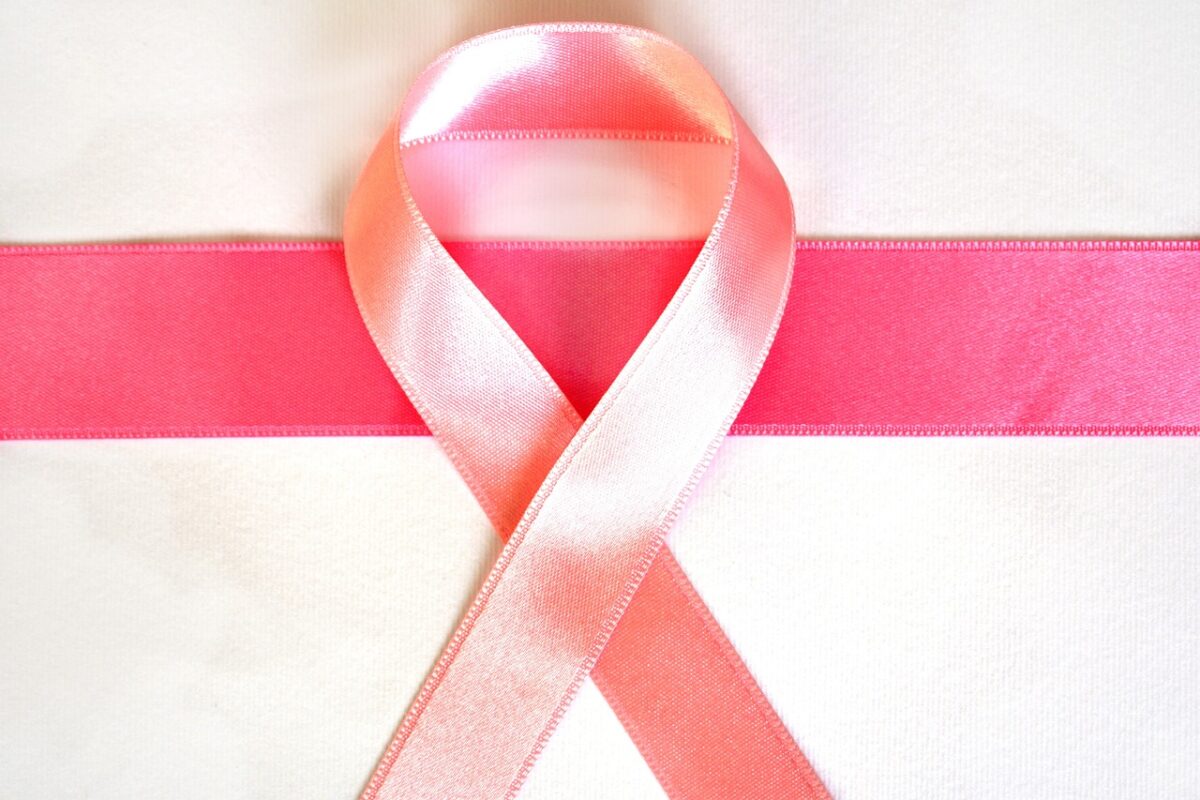 pink breast cancer awareness ribbon on white and pink background